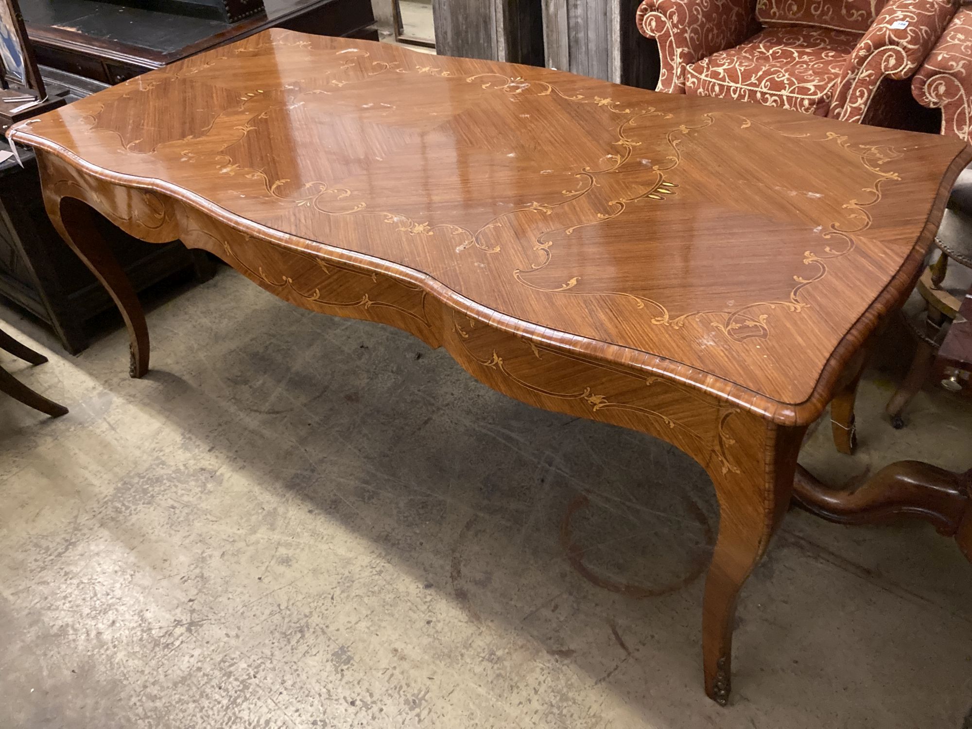 A Louis XVI design marquetry inlaid kingwood serpentine centre table W.196cm. D90cm. H 79cm.